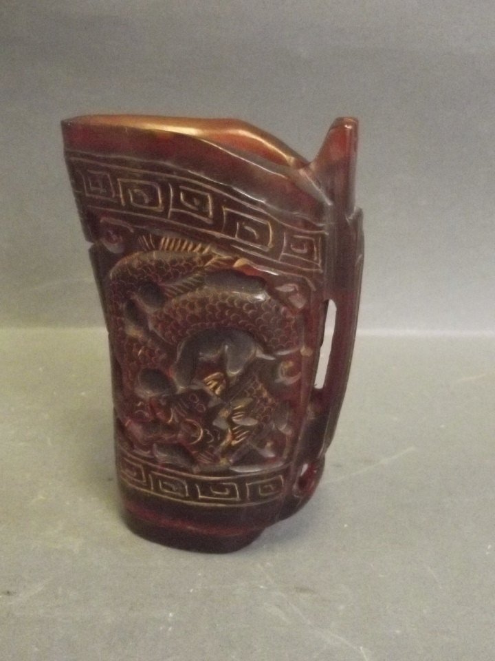 A Chinese carved horn libation cup with dragon: A Chinese carved horn libation cup with dragon decoration, 4'' high