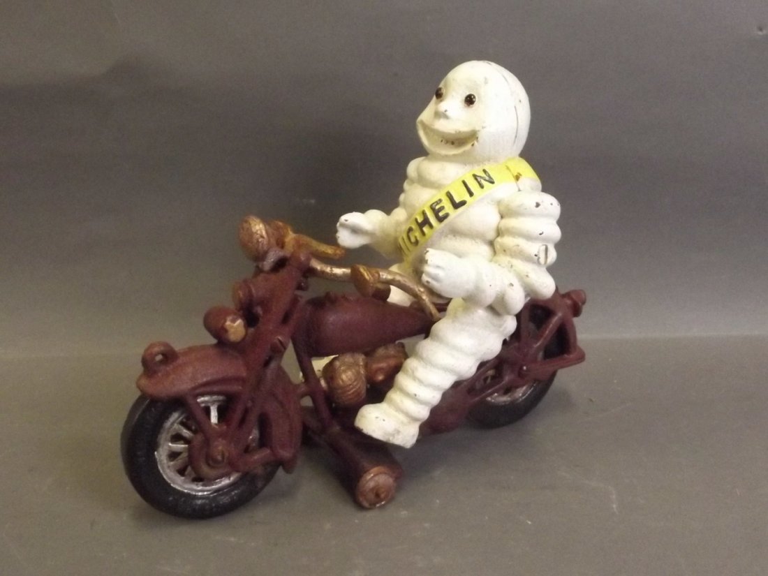 A novelty cast metal figure of the Michelin Man riding (1 of 2)