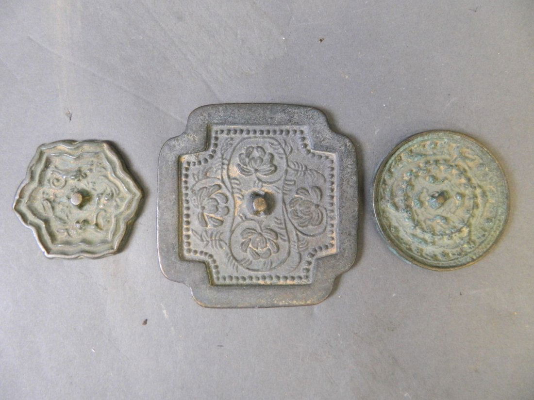 A collection of three Chinese patinated bronze mirrors (1 of 1)