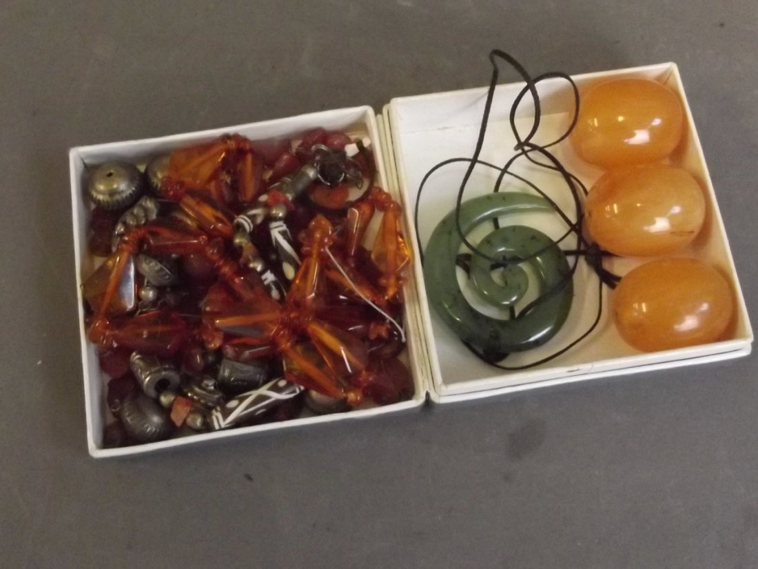 A jade pendant, and a quantity of amber and white metal: A jade pendant, and a quantity of amber and white metal beads