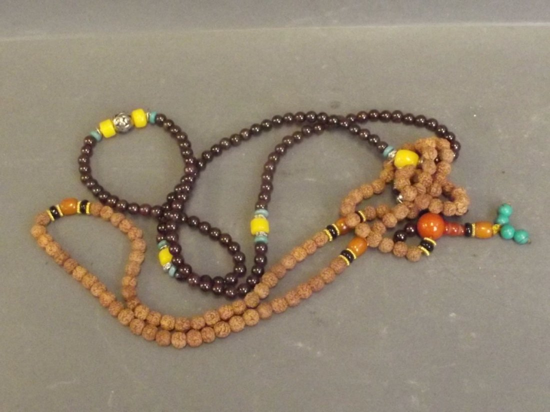 A string of coloured beads and pierced white metal, and: A string of coloured beads and pierced white metal, and a nut beaded necklace, 25'' long