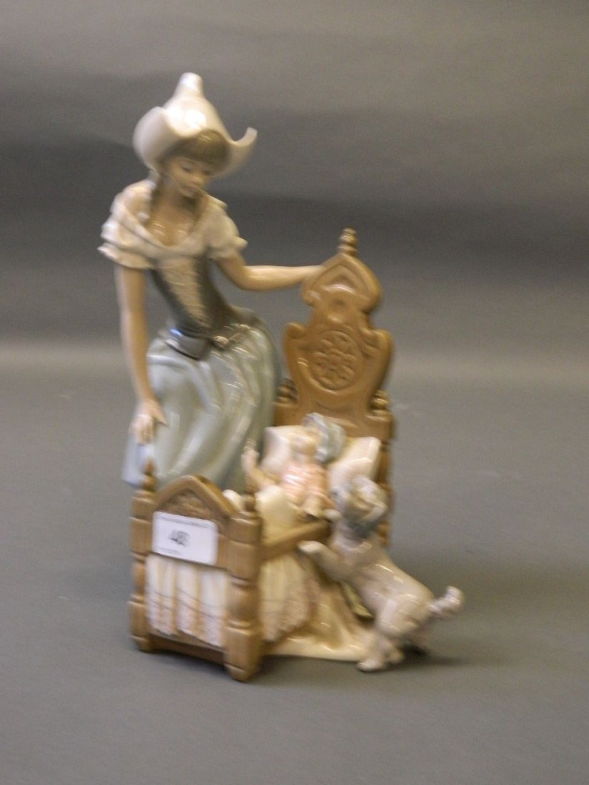 A Lladro figure of a young woman with child in a crib,: A Lladro figure of a young woman with child in a crib, 12'' high