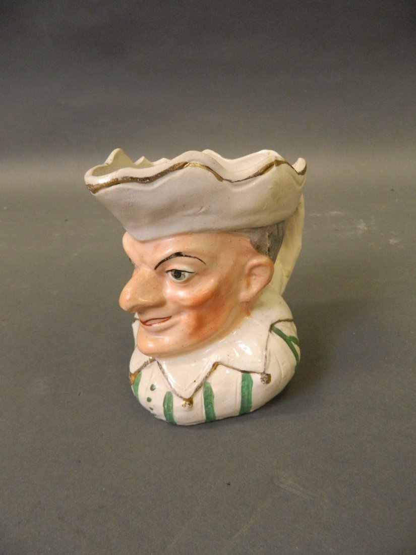 An early Staffordshire milk jug in the form of Mr: An early Staffordshire milk jug in the form of Mr Punch, 4'' high