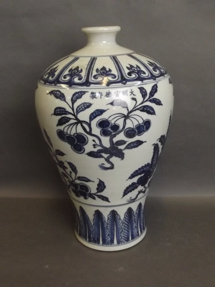 A Chinese blue and white vase decorated with fruiting: A Chinese blue and white vase decorated with fruiting trees and leaves, 13'' high