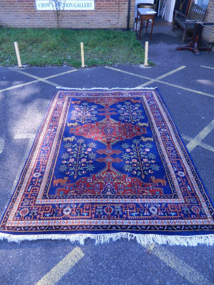 A Persian wool rug with geometric red medallion and (1 of 4)