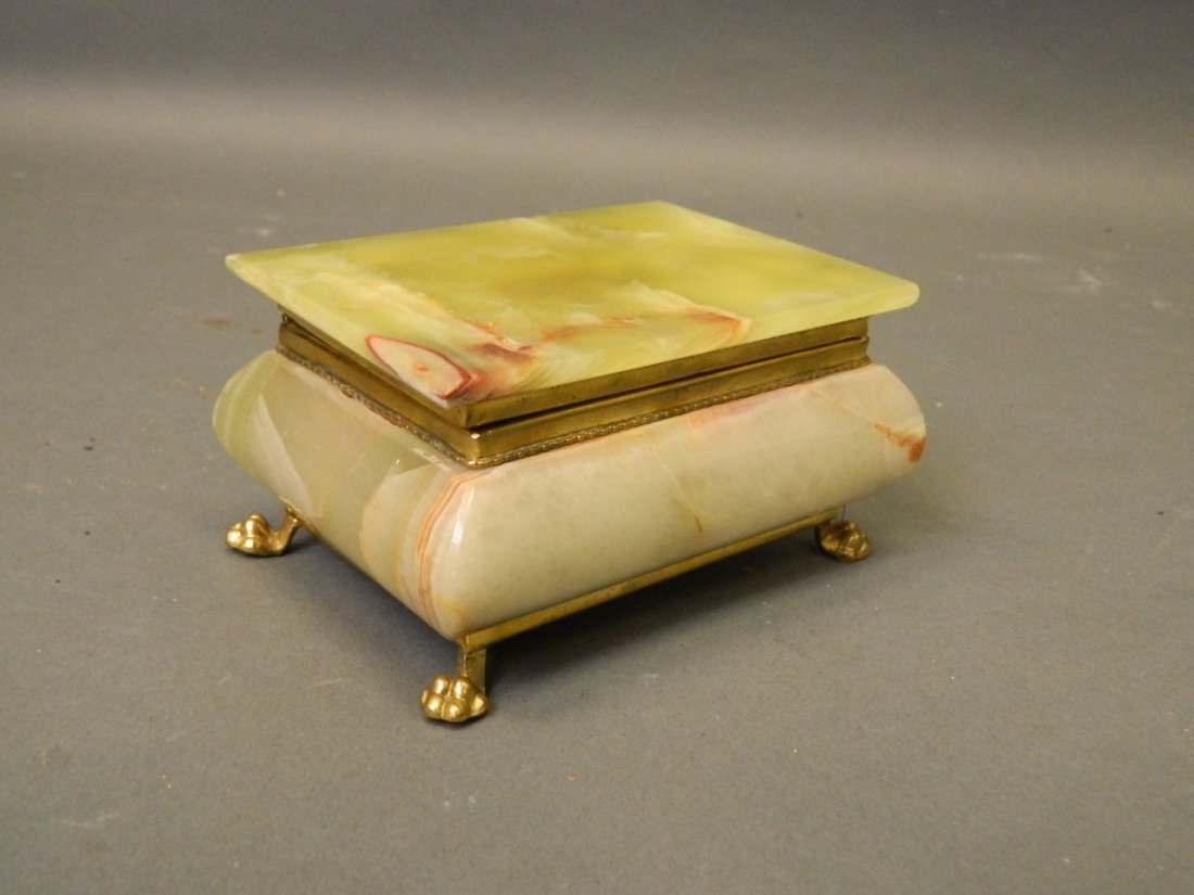 An onyx and gilt metal mounted trinket box on paw feet,: An onyx and gilt metal mounted trinket box on paw feet, 5½'' x 3''