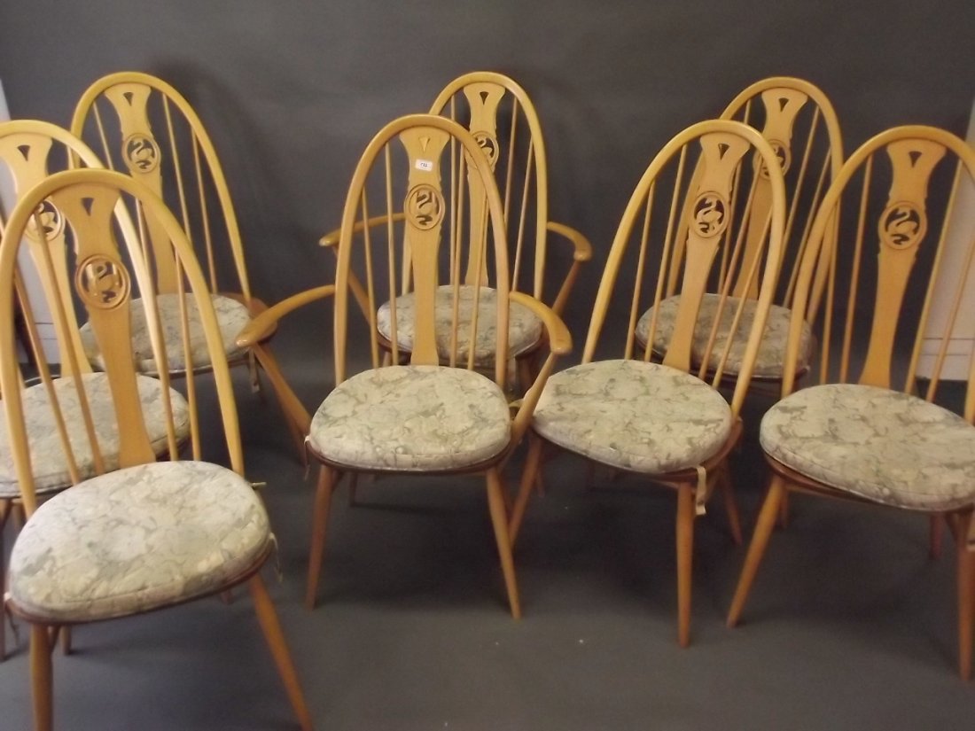 A set of eight Ercol beech hoop back dining chairs with: A set of eight Ercol beech hoop back dining chairs with swan carved back splats