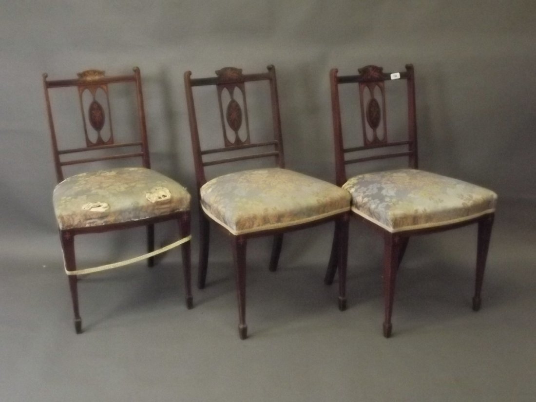 A set of three late C19th mahogany side chairs with: A set of three late C19th mahogany side chairs with pierced backs and fine inlaid decoration of musical instruments, swags and harebells