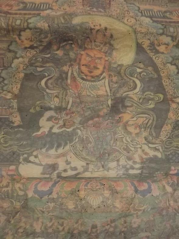 An Oriental thangka decorated with a deity in an: An Oriental thangka decorated with a deity in an elaborate temple and garden, 43" x 36" (AF)