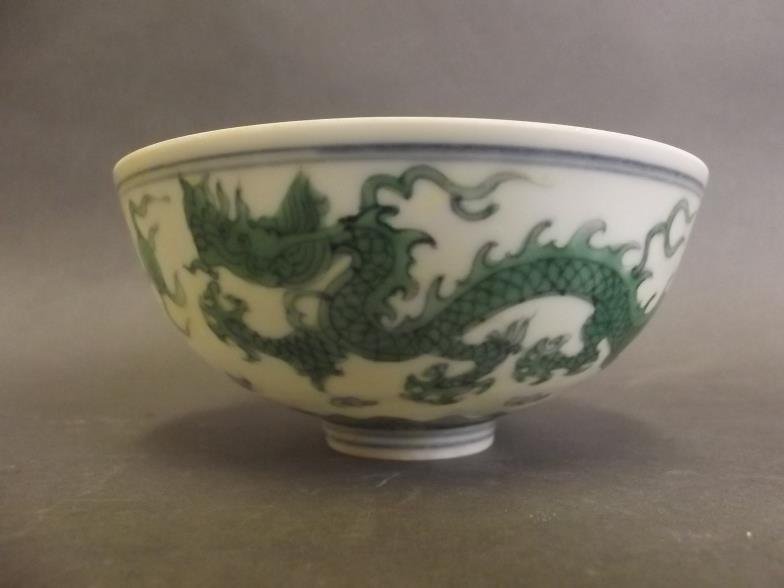 A Chinese porcelain bowl decorated with dragons in: A Chinese porcelain bowl decorated with dragons in green enamel, 6 character mark to base, 4Â½" diameter