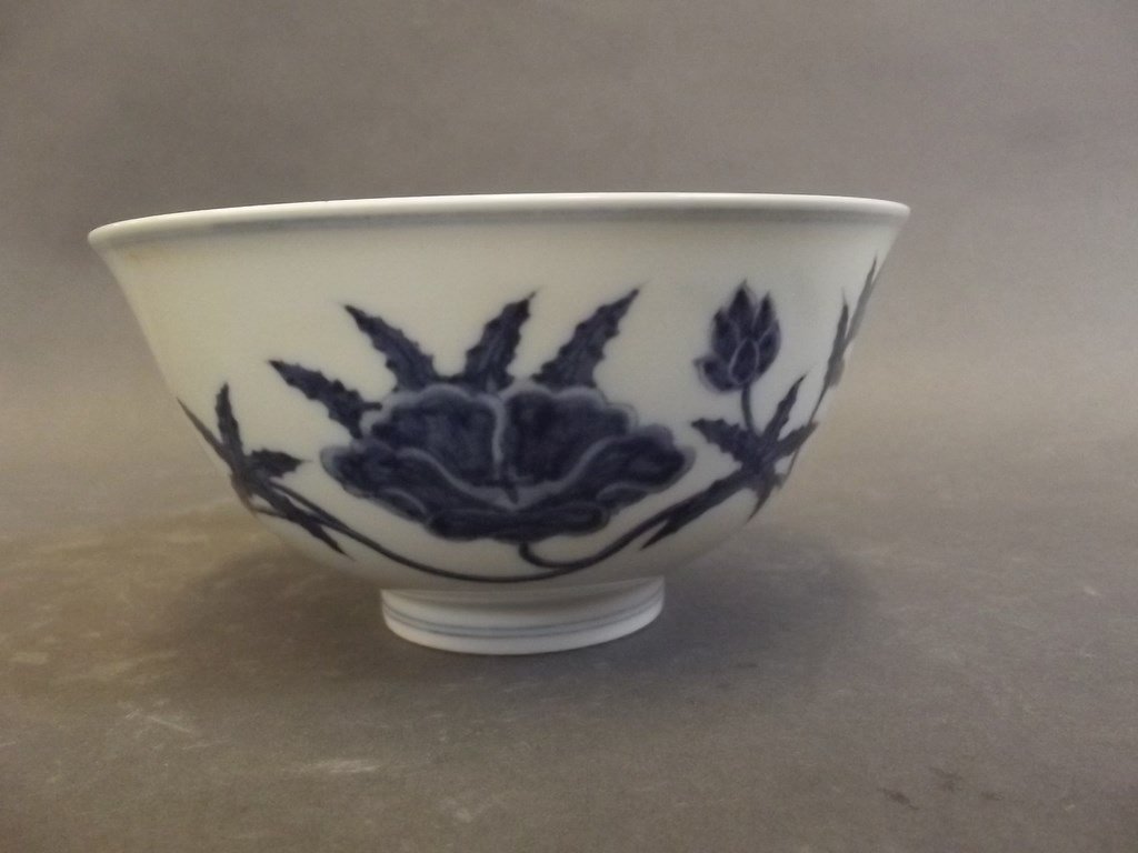 A Chinese blue and white porcelain bowl decorated with: A Chinese blue and white porcelain bowl decorated with trailing lotus, 6 character mark to base, 5Â½" diameter