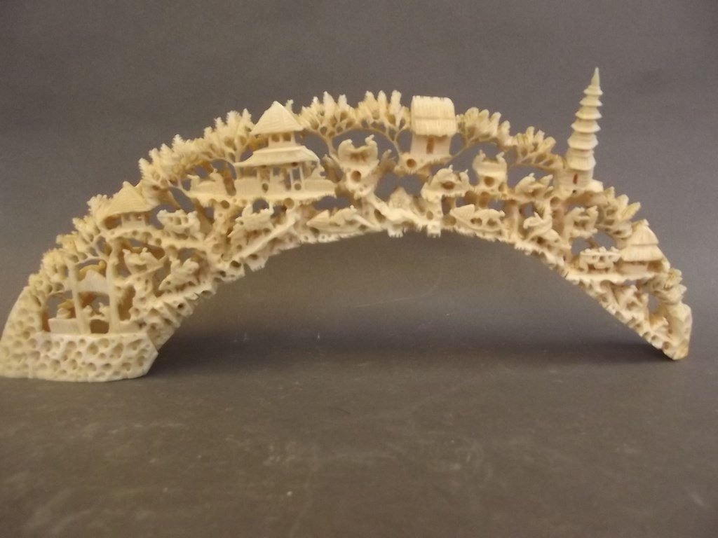 An ivory tusk with carved decoration of figures,: An ivory tusk with carved decoration of figures, buildings and trees, 11" long NO INTERNATIONAL SHIPPING OF IVORY.