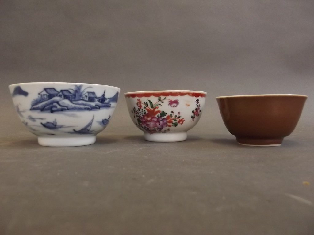 A Chinese blue and white porcelain tea bowl decorated: A Chinese blue and white porcelain tea bowl decorated with a coastal scene, another painted in the famille rose palette, and a third with brown glazed exterior and blue and white interior, 3Â½" diam