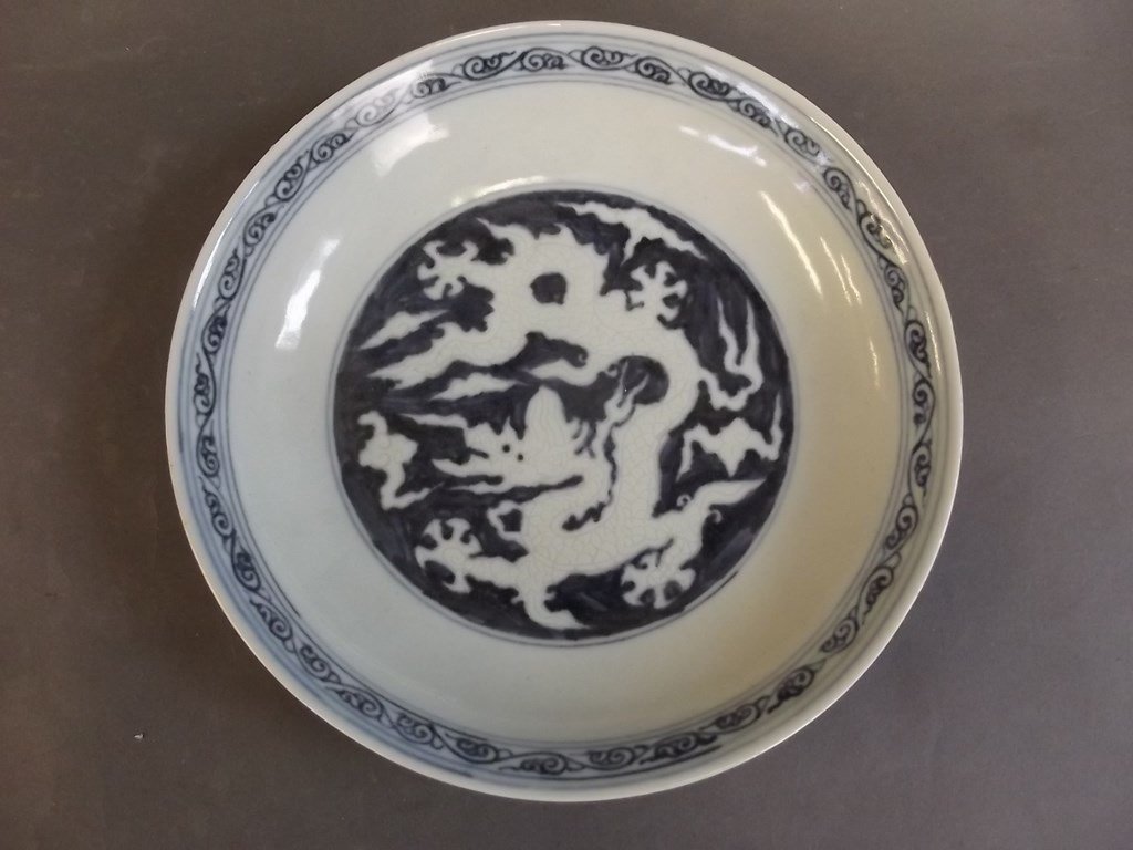 A Chinese blue and white porcelain dish decorated with: A Chinese blue and white porcelain dish decorated with dragons chasing the flaming pearl, 6 character mark to base, 8" diameter
