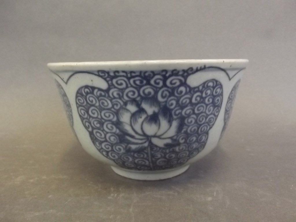 A Chinese blue and white porcelain bowl decorated with: A Chinese blue and white porcelain bowl decorated with stylised lotus flowers, 5" diameter