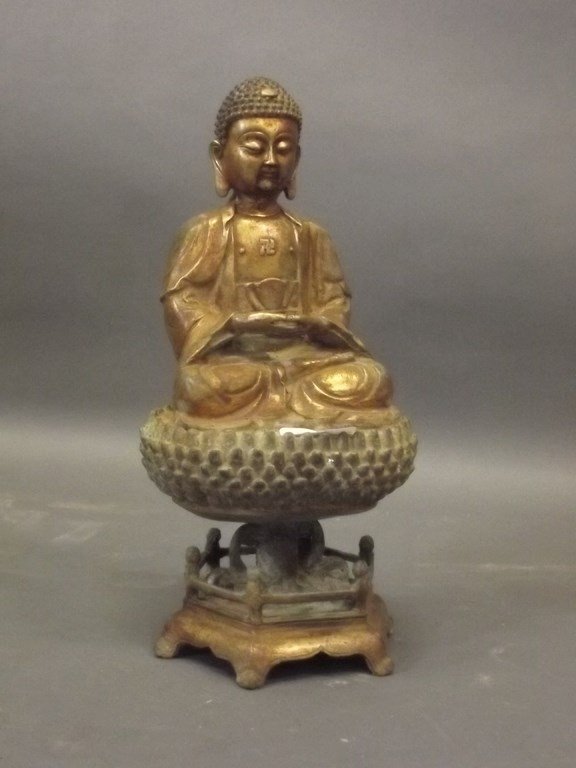 A Sino-Tibetan gilt bronze Buddha seated upon a raised (1 of 2)