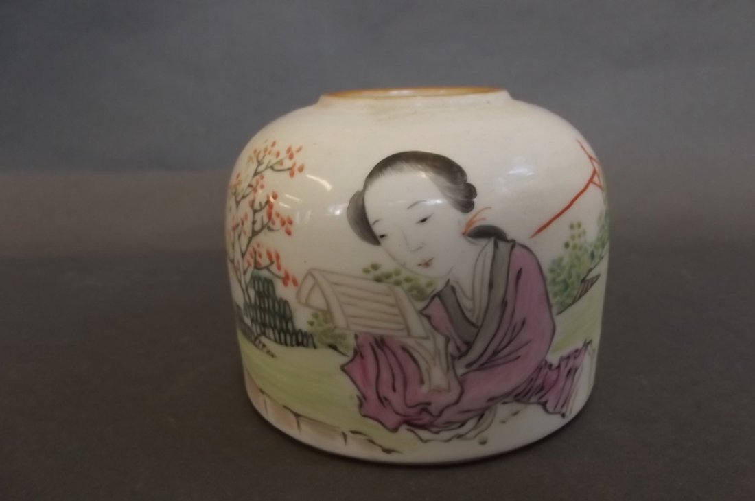 A Chinese porcelain brush wash decorated in bright: A Chinese porcelain brush wash decorated in bright enamels with a girl reading in a garden, signed with calligraphy, 3" high
