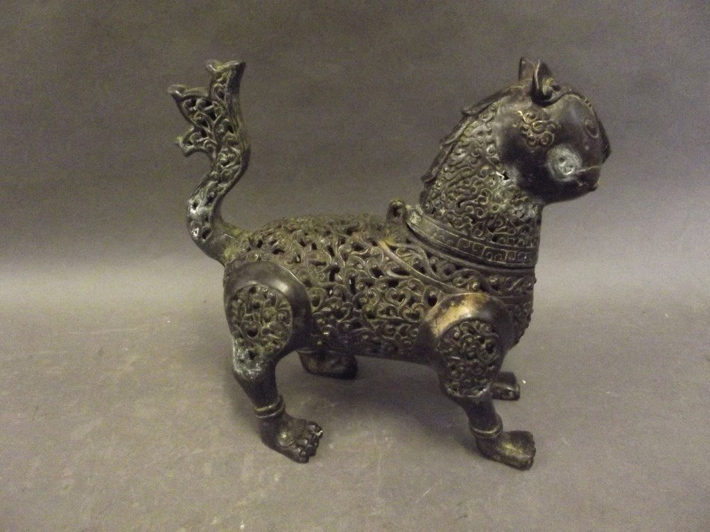 A Persian iron incense burner in the form of an exotic: A Persian iron incense burner in the form of an exotic beast with pierced scrolling decoration