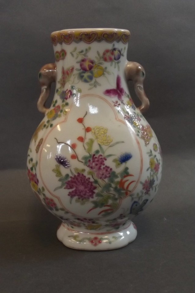A Chinese porcelain vase with elephant head handles: A Chinese porcelain vase with elephant head handles decorated in the famille rose palette, red seal mark to base, 7" high