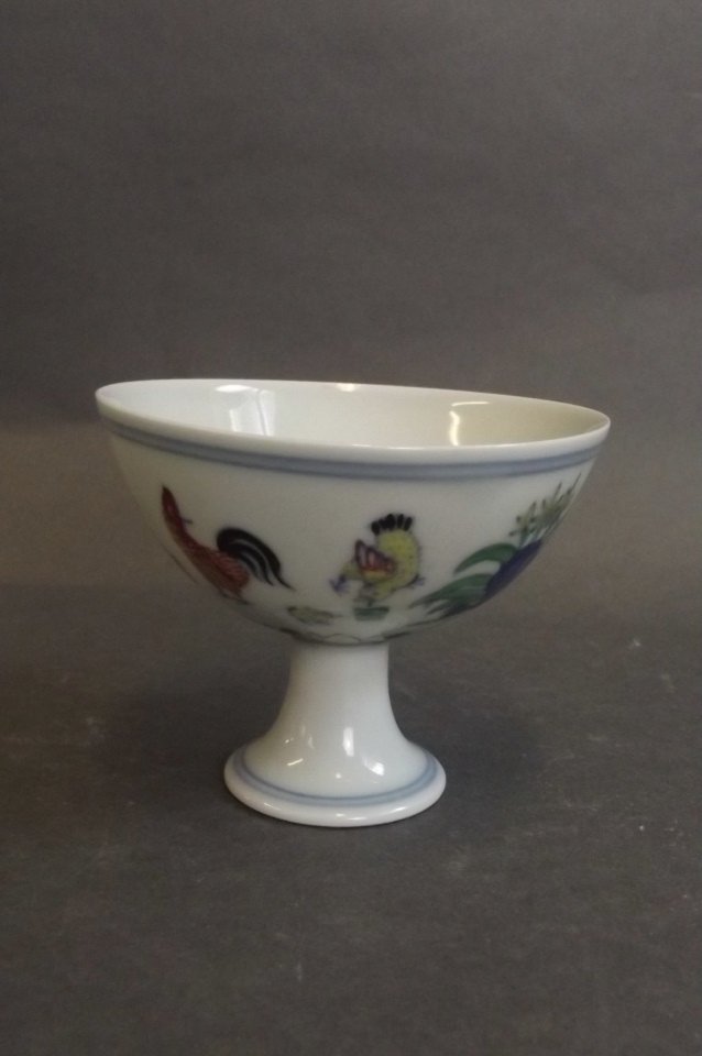 A Chinese Doucai enamel porcelain stem bowl with: A Chinese Doucai enamel porcelain stem bowl with chicken decoration, 6 character mark to base, 3" diameter