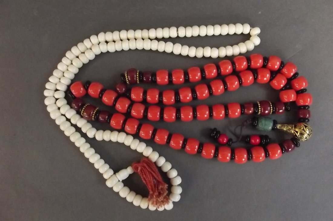 An Oriental coral coloured bead necklace, and a bone: An Oriental coral coloured bead necklace, and a bone bead necklace, longest 28"