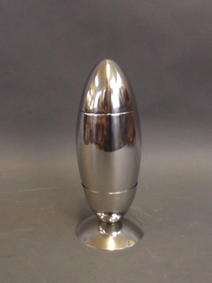 A silver plated novelty cocktail shaker and stand in: A silver plated novelty cocktail shaker and stand in the form of a missile, 7" high