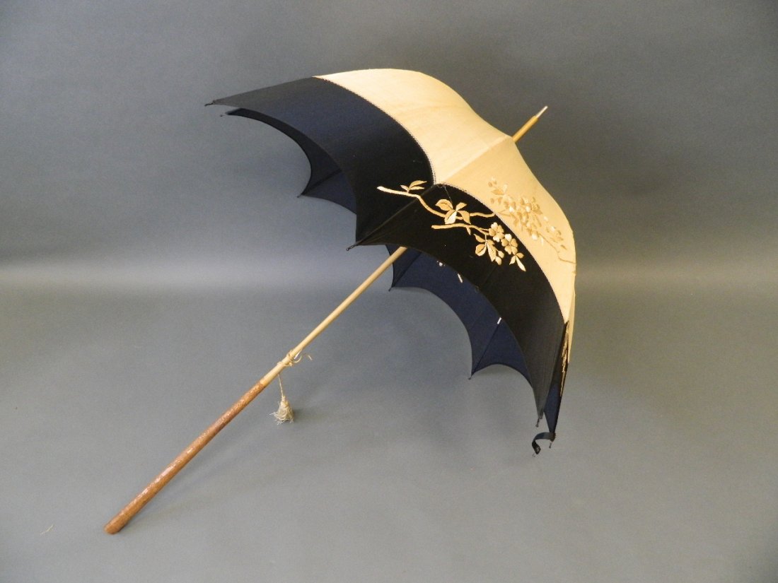 An Oriental silk parasol with long carved bamboo: An Oriental silk parasol with long carved bamboo handle, 42½" long