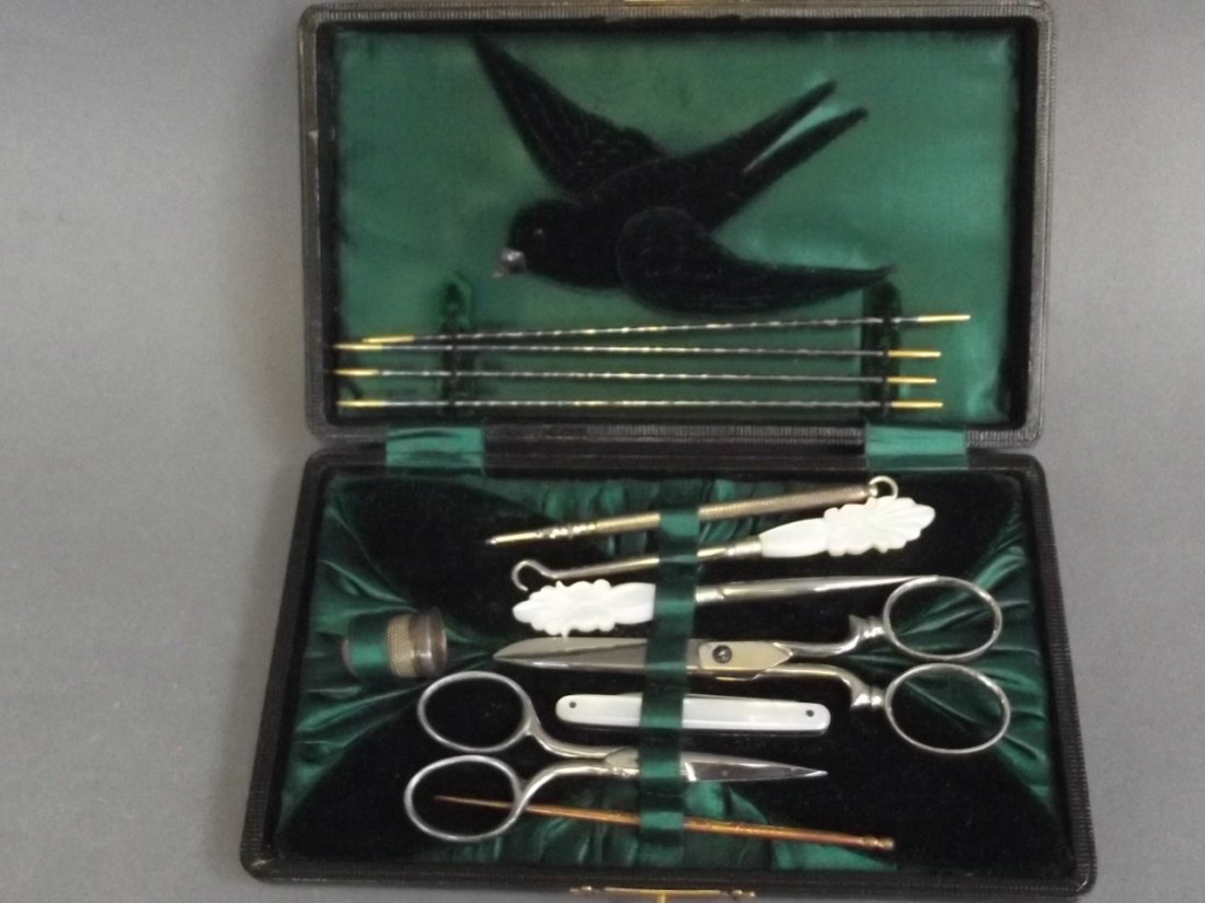 A leather cased sewing set containing scissors, Mother: A leather cased sewing set containing scissors, Mother of Pearl handled button hook, stilettos, penknife etc, 7" x 4"