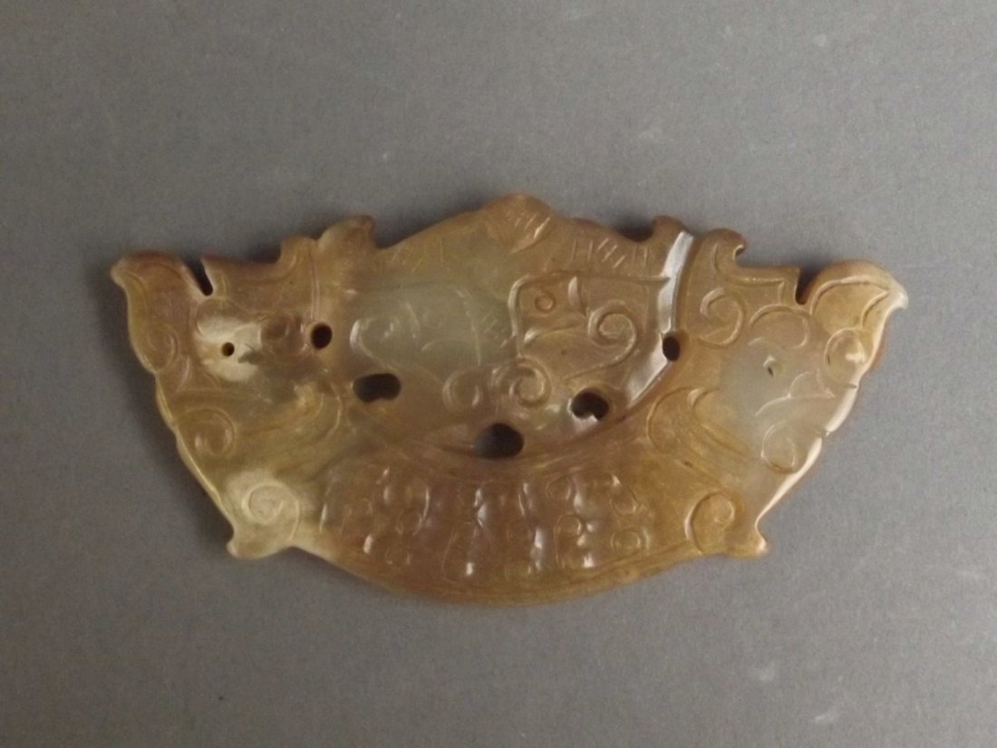 A Chinese carved jade pendant in the form of a mythical: A Chinese carved jade pendant in the form of a mythical beast, 4" x 2"