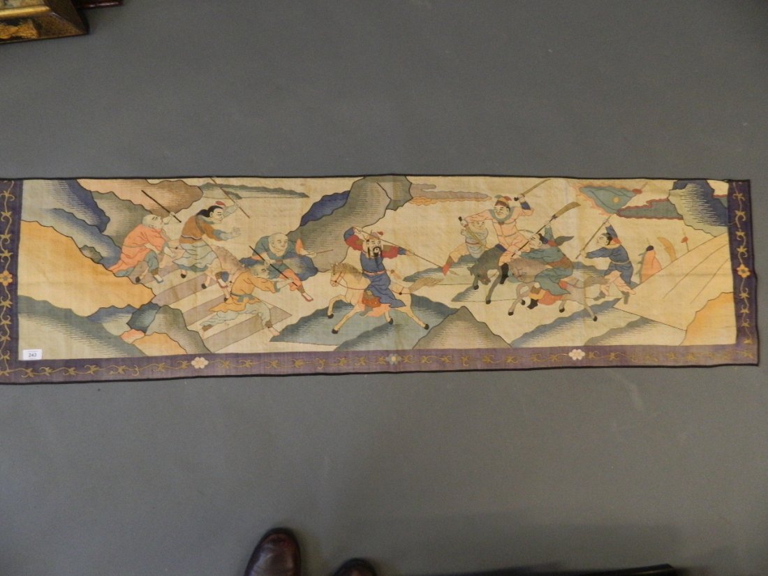 A Chinese silk embroidered wall hanging depicting: A Chinese silk embroidered wall hanging depicting warriors on horseback, 17" x 66"