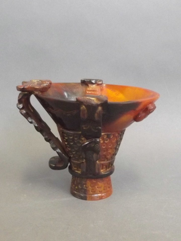 A Chinese carved horn libation cup with kylin: A Chinese carved horn libation cup with kylin decoration, 5" high