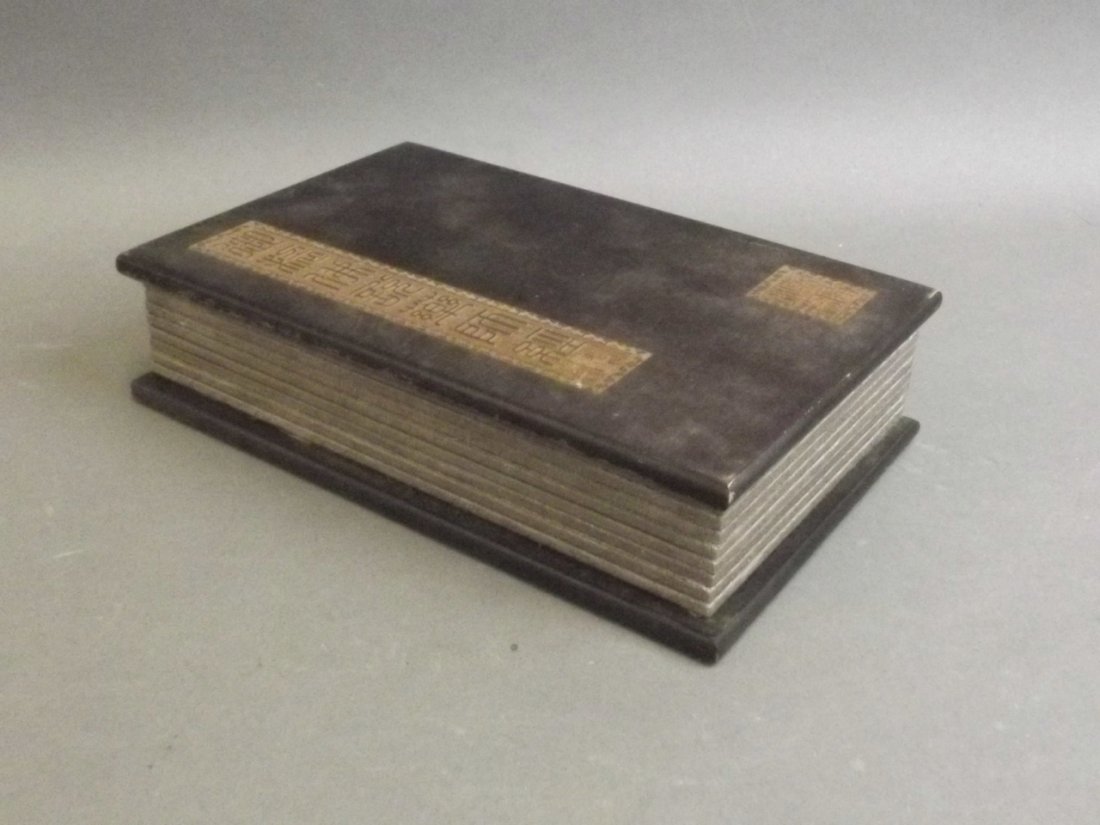 A Chinese cloth and hardwood bound book containing: A Chinese cloth and hardwood bound book containing white jade tablets decorated with calligraphy and Buddha, 5½" x 9"