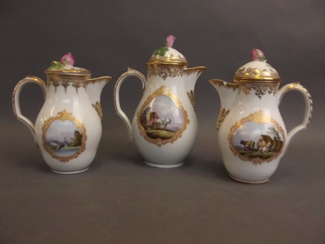 Three early Royal Copenhagen porcelain chocolate pots: Three early Royal Copenhagen porcelain chocolate pots painted with panels of rural scenes and gilt highlights, the lids with flower bud handles, largest 7" high