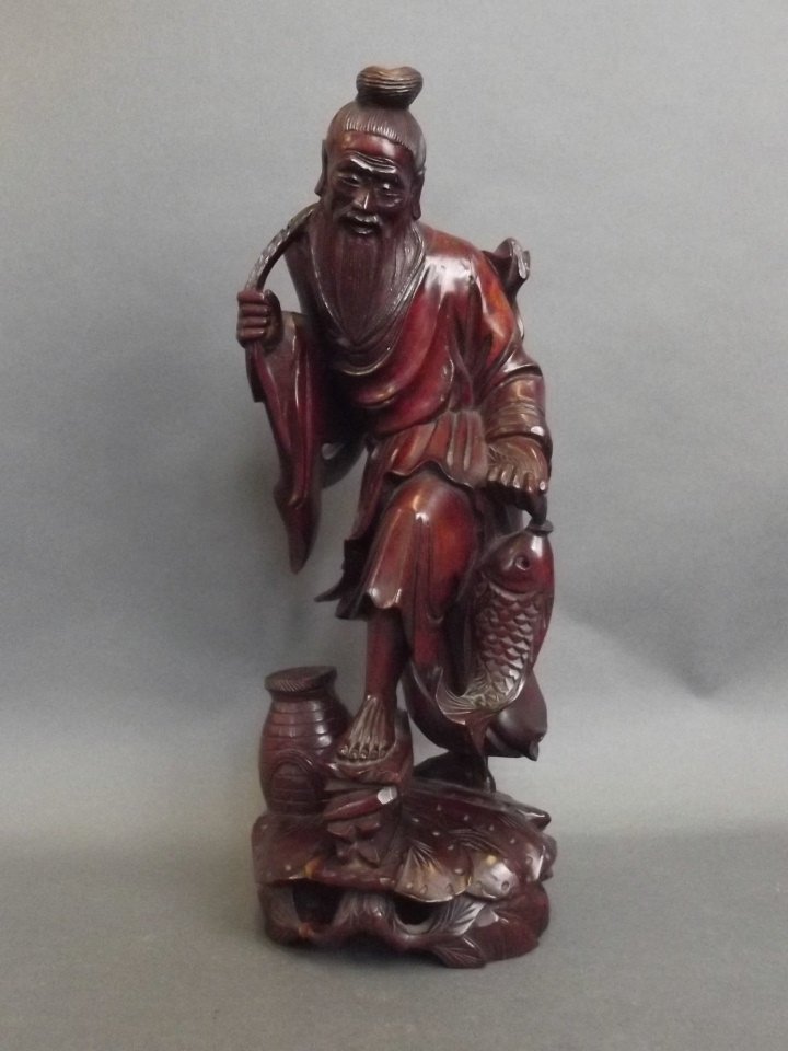 An Oriental rootwood carving of a fisherman with his (1 of 3)