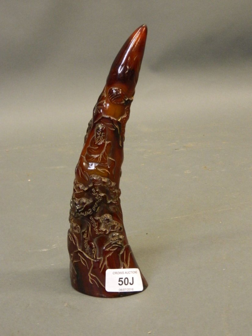 A Chinese carved horn ornament with raised decoration: A Chinese carved horn ornament with raised decoration of men playing chequers under a cypress tree, inscribed with six characters, 9" high