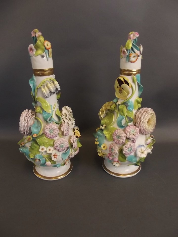 A pair of C19th Continental porcelain jars and covers: A pair of C19th Continental porcelain jars and covers with applied floral decoration, 12" high