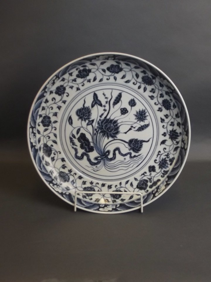 A large Chinese blue and white porcelain charger with: A large Chinese blue and white porcelain charger with painted lotus flower decoration, 13" diameter