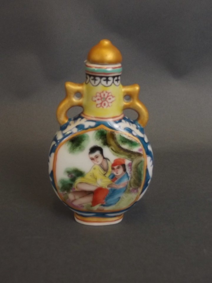 A Chinese twin handled porcelain snuff bottle with: A Chinese twin handled porcelain snuff bottle with enamelled erotic decoration, 4 character mark to base, 3" high