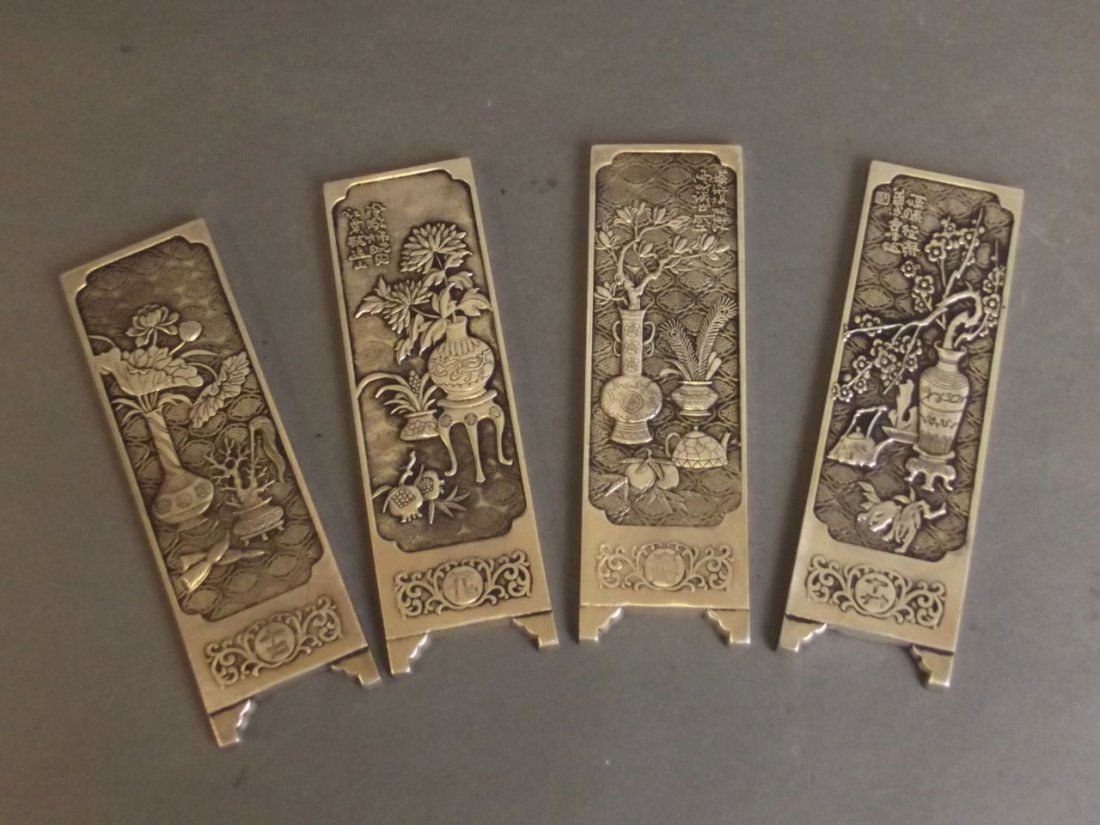 A set of four Chinese metal scroll weights with chased (1 of 2)