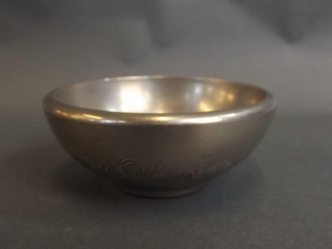 A Chinese silvered metal trinket bowl with raised bat: A Chinese silvered metal trinket bowl with raised bat and dragon decoration, seal mark to base, 4" diameter