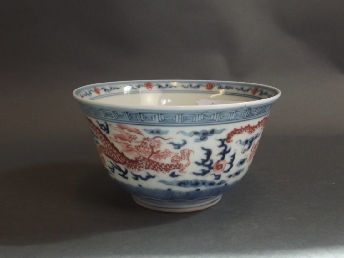 A Chinese blue and white porcelain rice bowl with: A Chinese blue and white porcelain rice bowl with painted iron red dragon and flaming pearl decoration, seal mark to base, 4" high