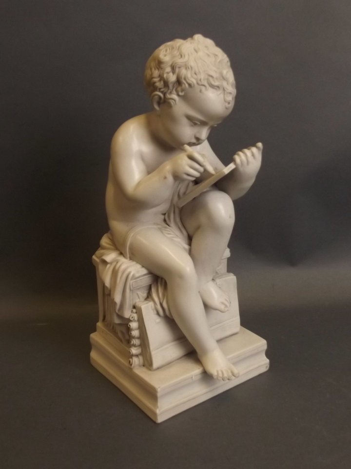 A composition figure of a cherub making notes,: A composition figure of a cherub making notes, inscribed verso 'Dilettante', 10" high