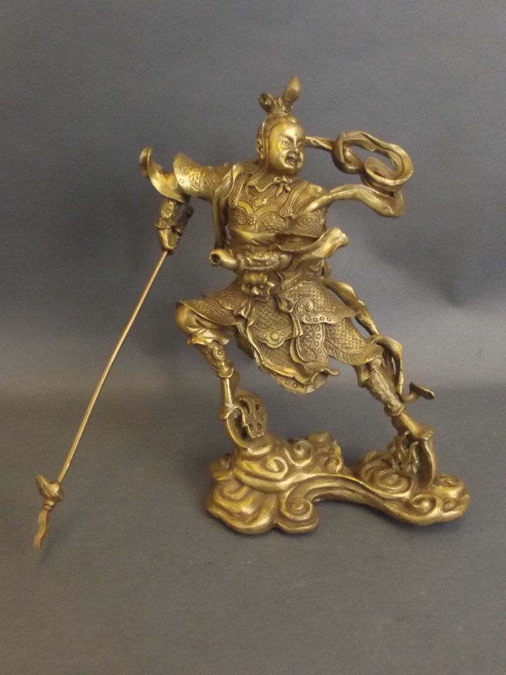A Chinese brass figure of a warrior deity with a spear,: A Chinese brass figure of a warrior deity with a spear, 9" high