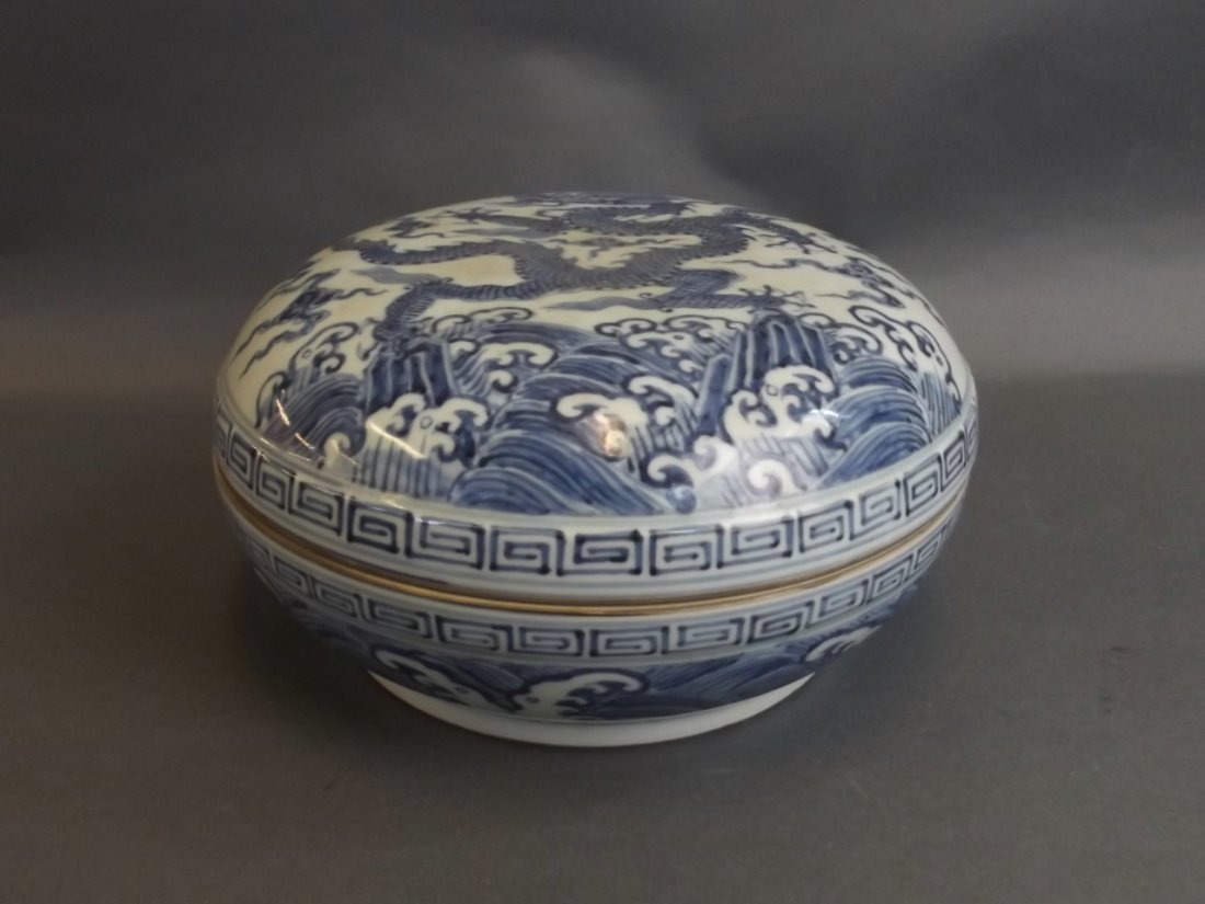 A Chinese Ming style blue and white porcelain pot and: A Chinese Ming style blue and white porcelain pot and cover with painted decoration of a dragon chasing the flaming pearl, 6 character mark to base, 9" diameter