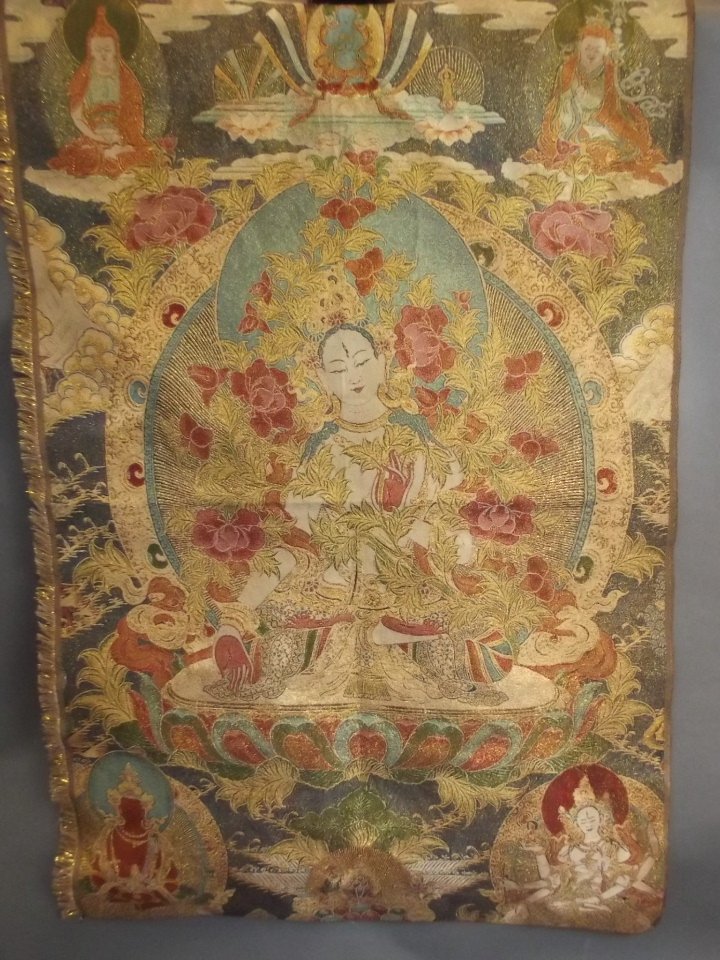 A Chinese silk and gilt thangka depicting the many: A Chinese silk and gilt thangka depicting the many faces of Buddha, 24" x 35"