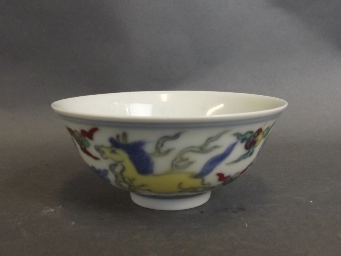 A Chinese Doucai porcelain tea bowl decorated with four: A Chinese Doucai porcelain tea bowl decorated with four horses, 6 character mark to base, 3" diameter