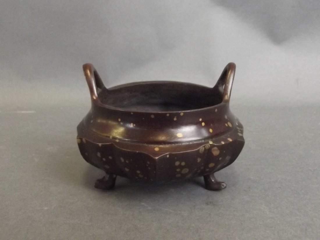 A Chinese bronze petal shaped censer with gilt splash: A Chinese bronze petal shaped censer with gilt splash decoration and twin handles, seal mark to base, 3" diameter