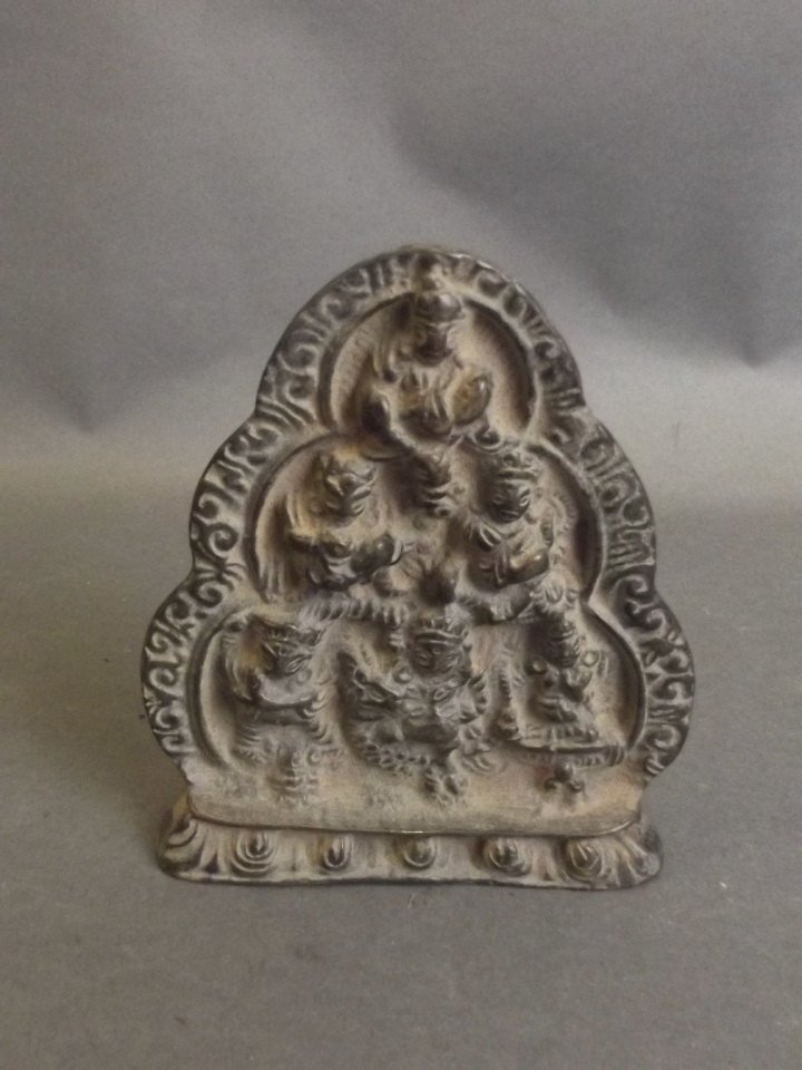 A Tibetan bronze plaque depicting the many faces of: A Tibetan bronze plaque depicting the many faces of Buddha, 4" high