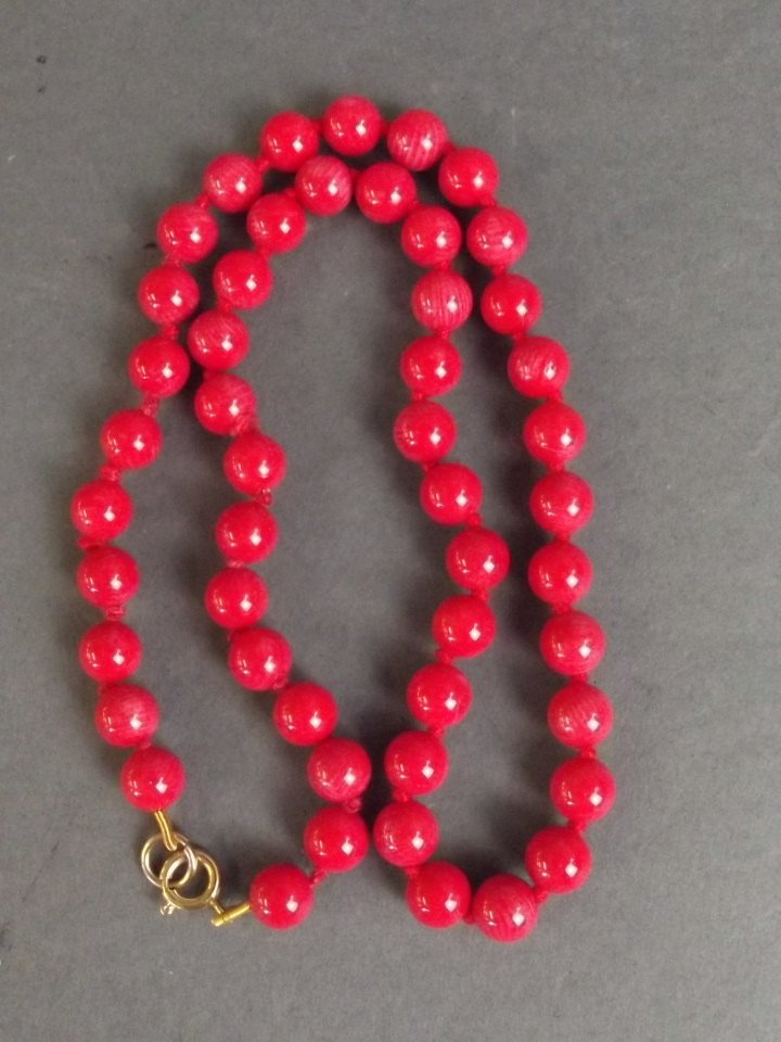 A coral bead necklace with gilt clasp, 18" long: A coral bead necklace with gilt clasp, 18" long