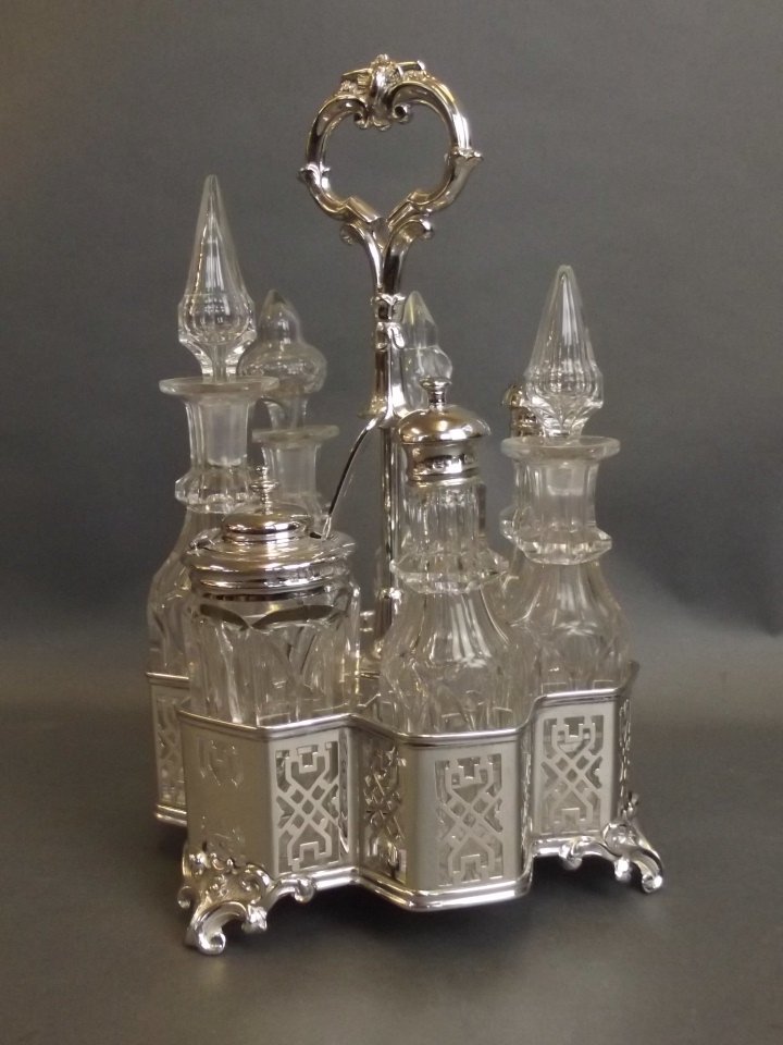 A seven glass bottle cruet in white metal, standing on (1 of 3)